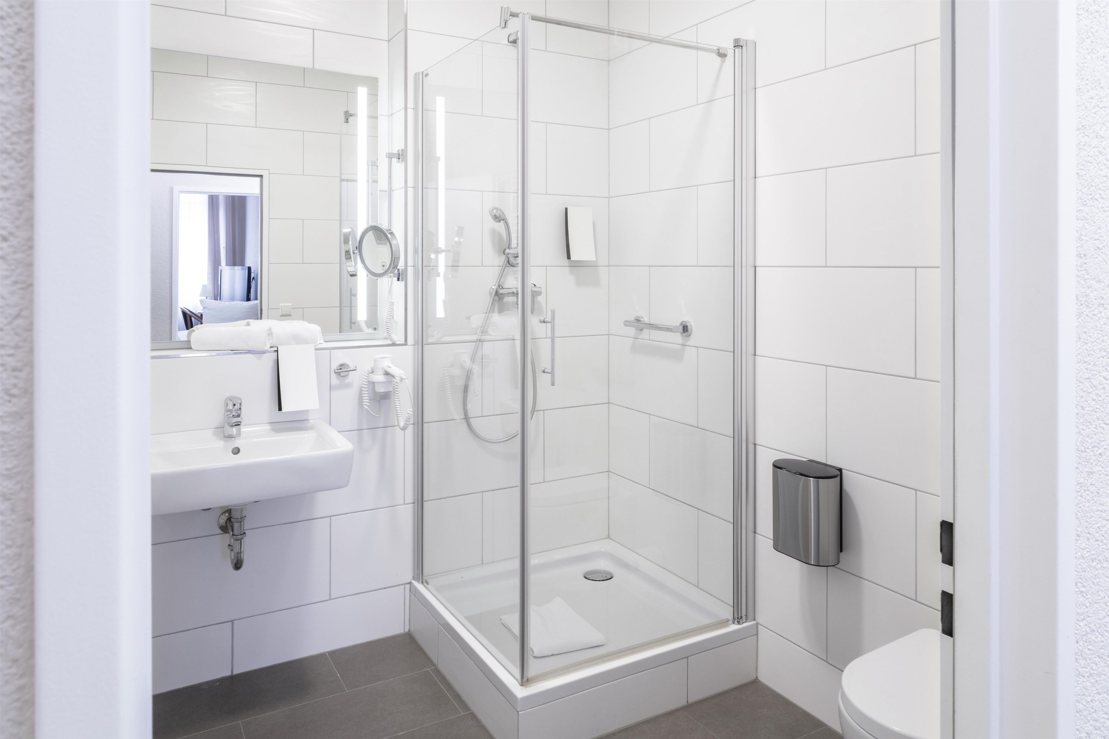 Une salle de bain moderne avec une douche à parois de verre, un lavabo et des toilettes.