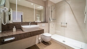 Een moderne badkamer met een wastafel, toilet en douchecabine.