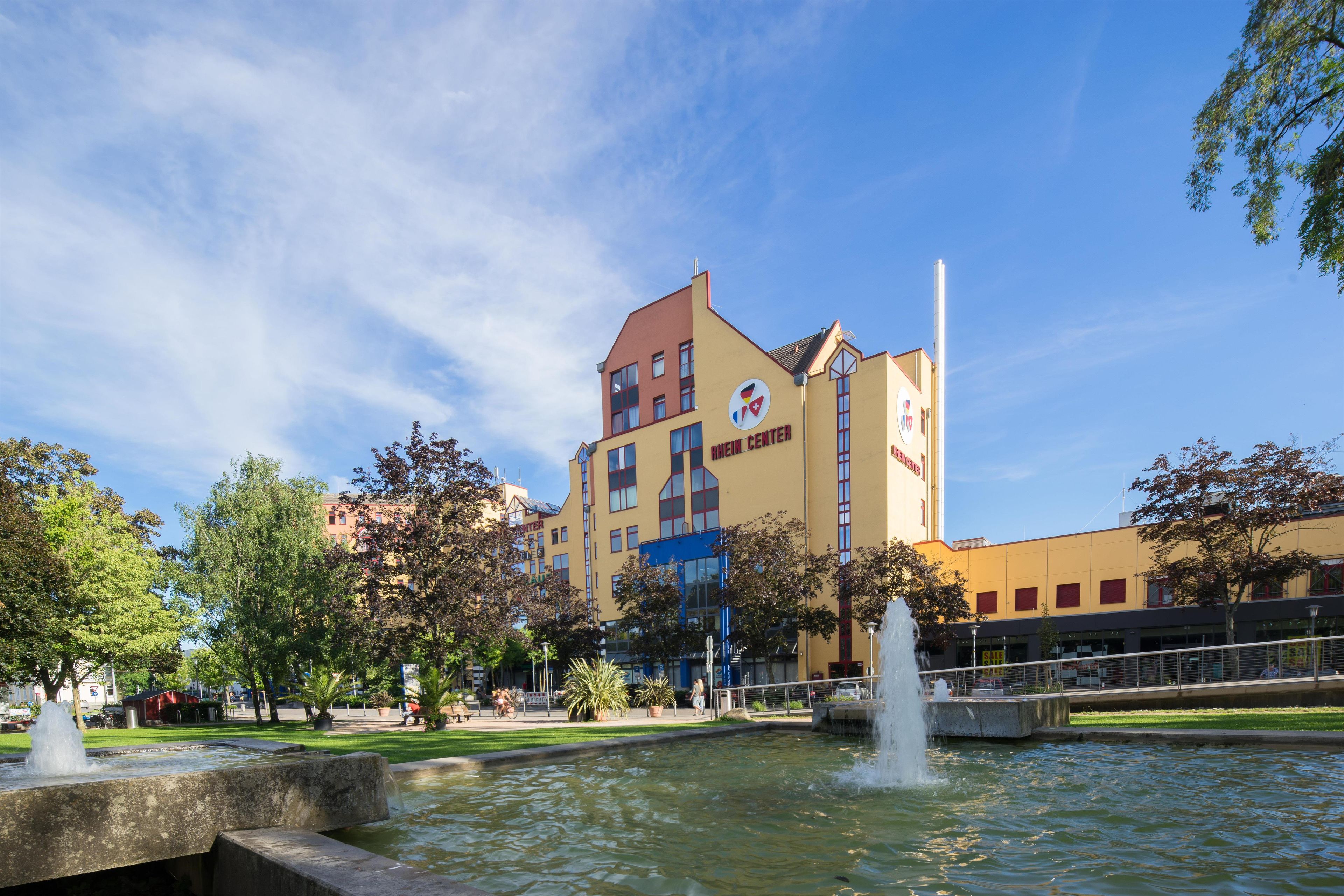 A building with a sign reading 'NEW CENTER' and a fountain in the foreground.