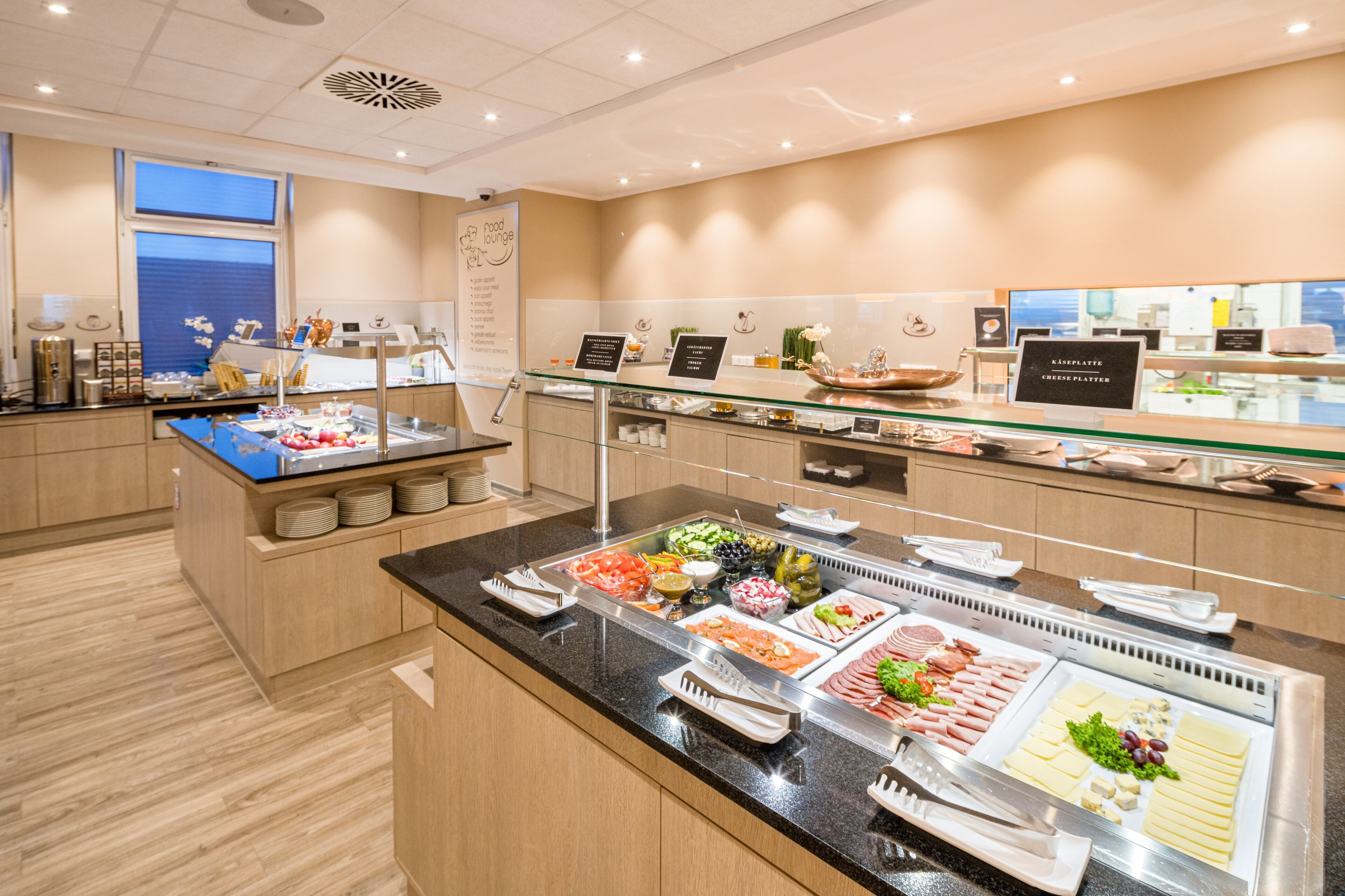 A buffet with various food items and a glass display case.