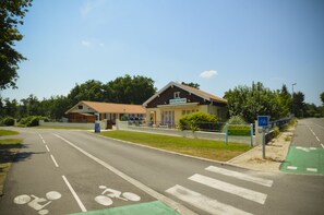 A hotel with a sign reading "Hotel Les Pins" and a bicycle lane.