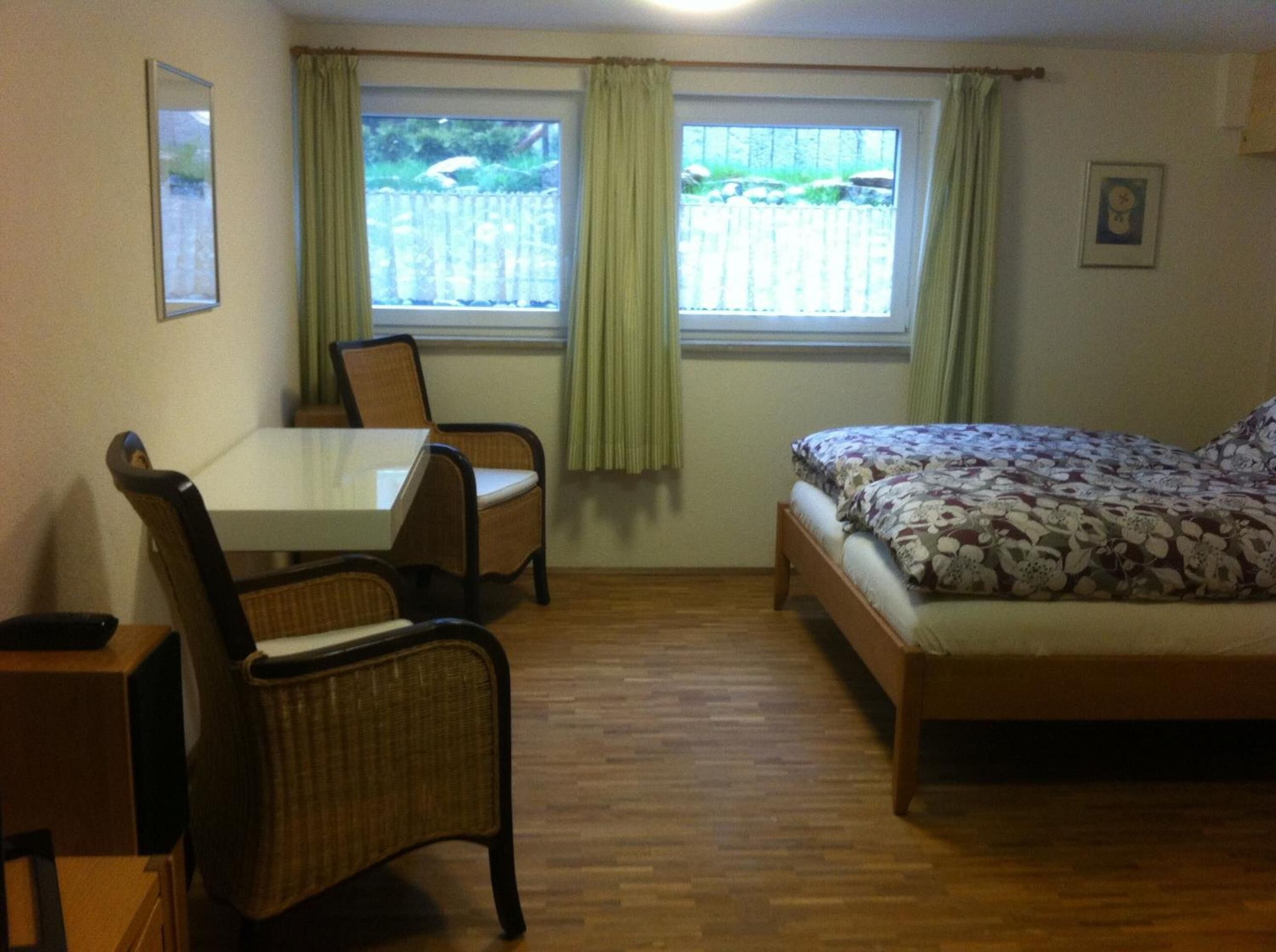 A small, cozy room with a single bed, a table, and two chairs.