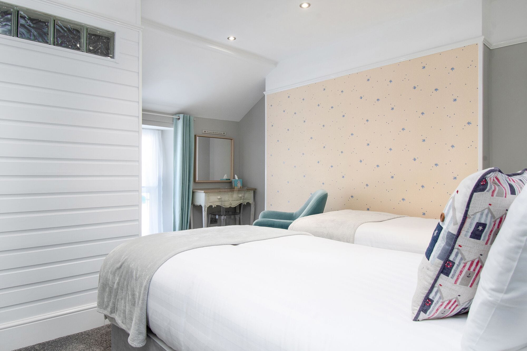 Une chambre à coucher avec un lit, une chaise, une commode et un miroir.