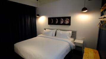 Una camera da letto con un letto, un comodino, una panca di legno e un quadro a parete raffigurante le fasi lunari.