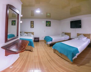 A hotel room with two beds, a wooden bench, a TV, and artwork on the walls.