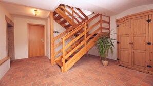 A wooden staircase with a brick floor, a wooden door, and a wooden cabinet. - Nostalgic renovated farmhouse in beautiful surroundings (Božanov)