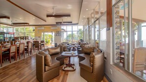 A spacious indoor area with leather sofas, wooden tables, and a bar area with a Coca-Cola refrigerator. - Kabilas Resort and Funpark (Kabilas)