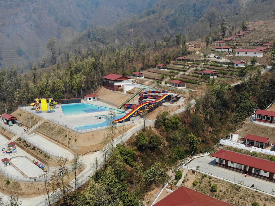 A resort with a pool, water slides, and a Ferris wheel.
