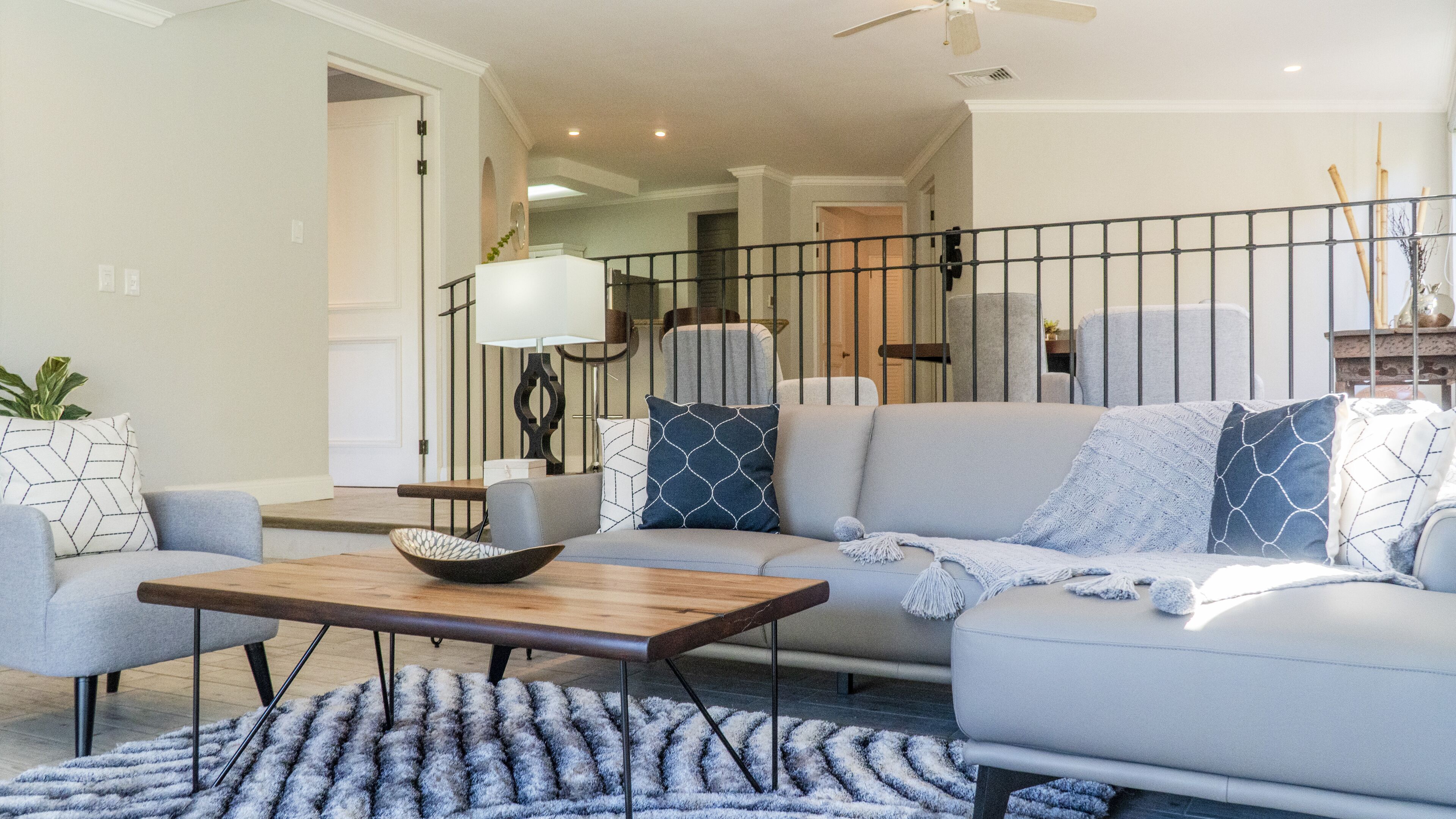 A living room with a sofa, coffee table, and a patterned rug.
