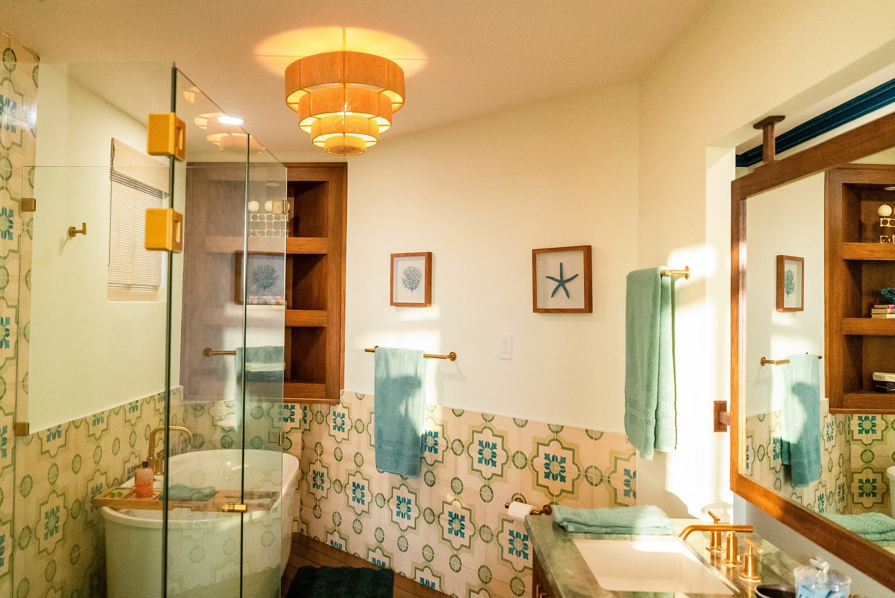 Une salle de bain avec une douche à parois de verre, une baignoire, un lavabo et un miroir.