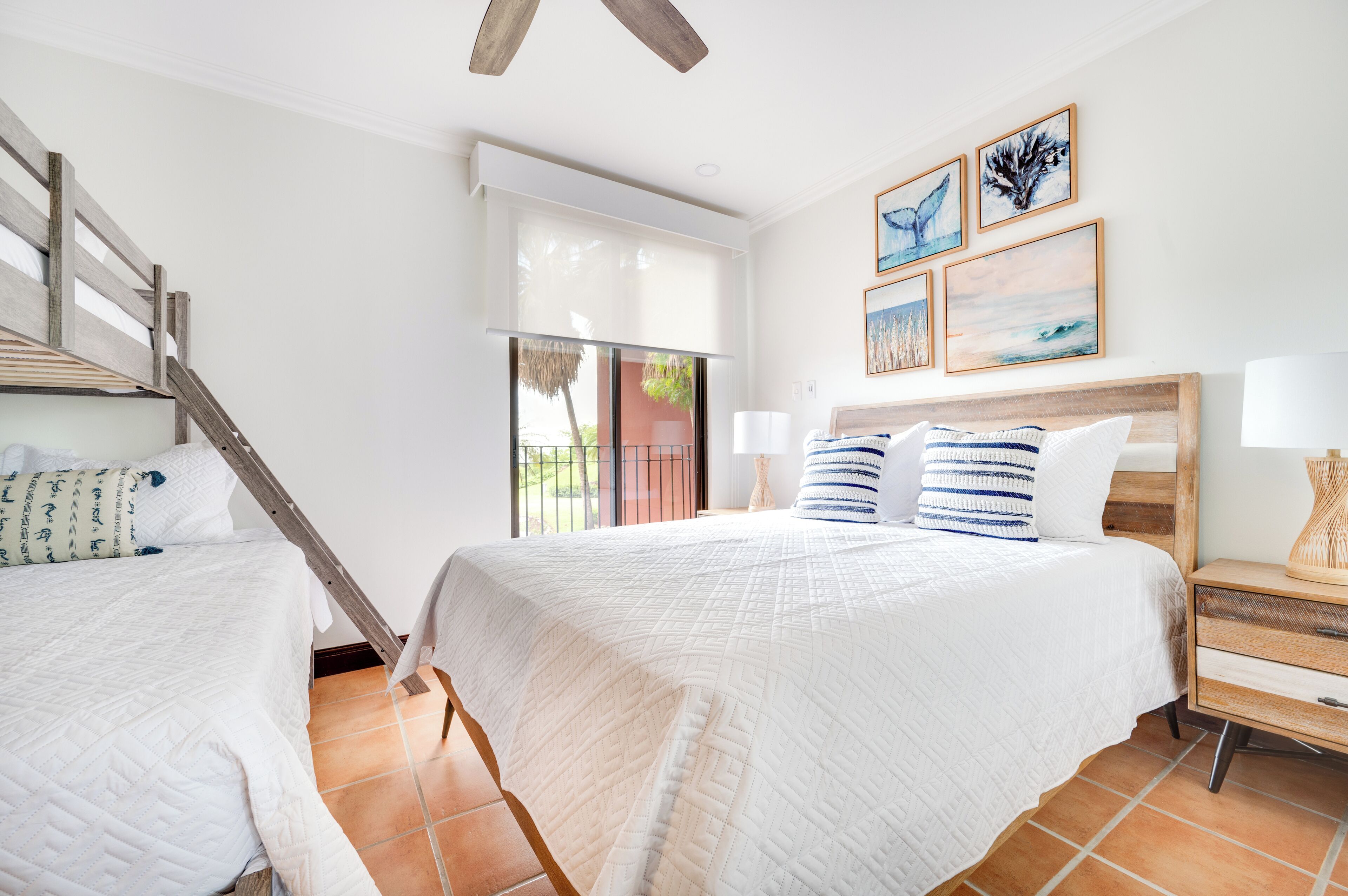 Une chambre avec un grand lit, une tête de lit en bois, une table de chevet et une fenêtre donnant sur un paysage verdoyant.