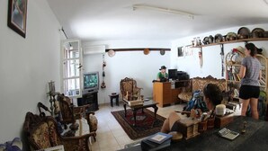 Una sala de estar con televisión, un sofá, una mesita de centro y una estantería.