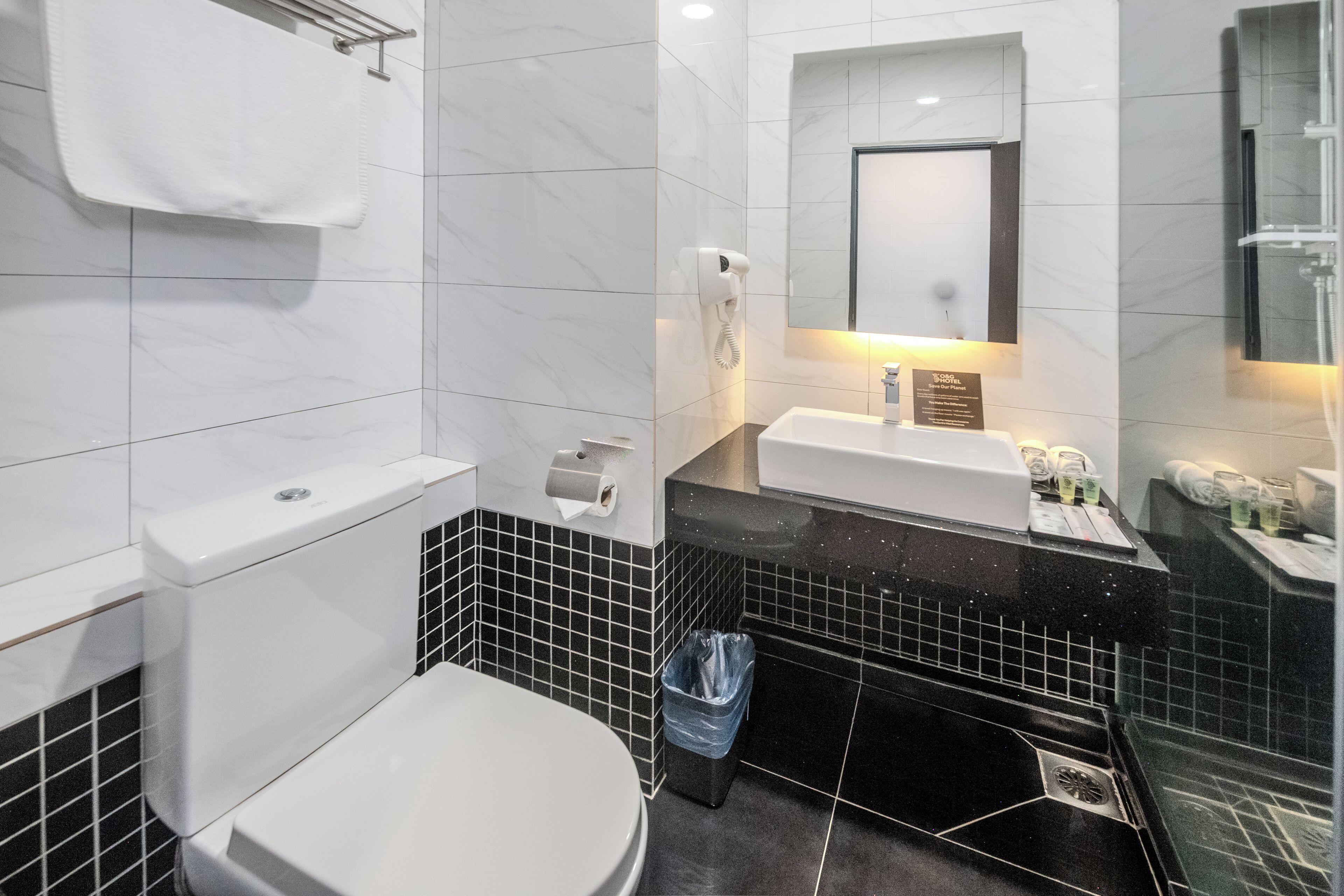 A modern bathroom with a toilet, sink, and mirror.