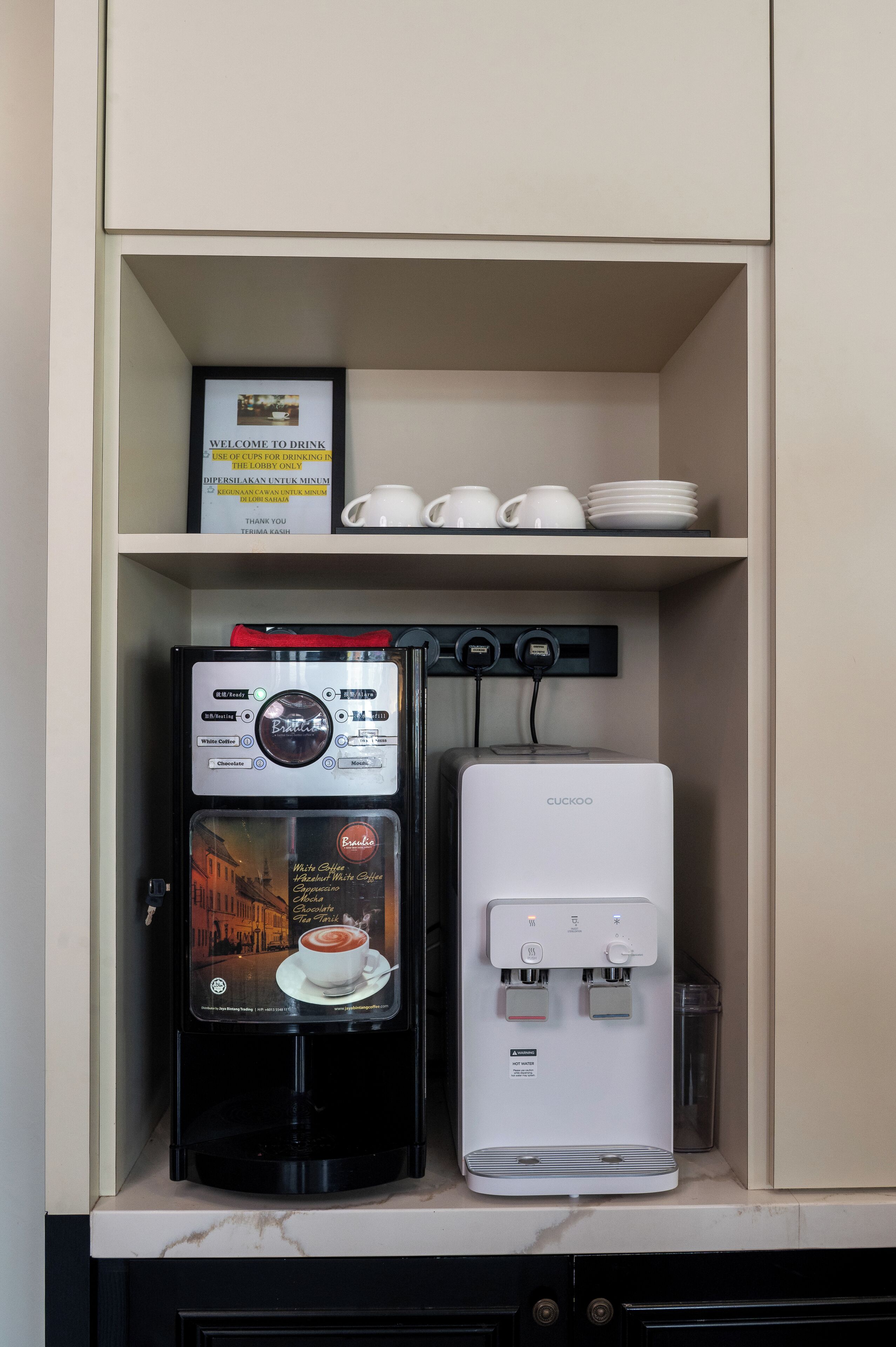 Eine Kaffeemaschine und ein Wasserspender in einem Schrank.