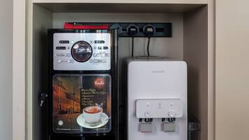 Una máquina de café y un dispensador de agua en un mueble.