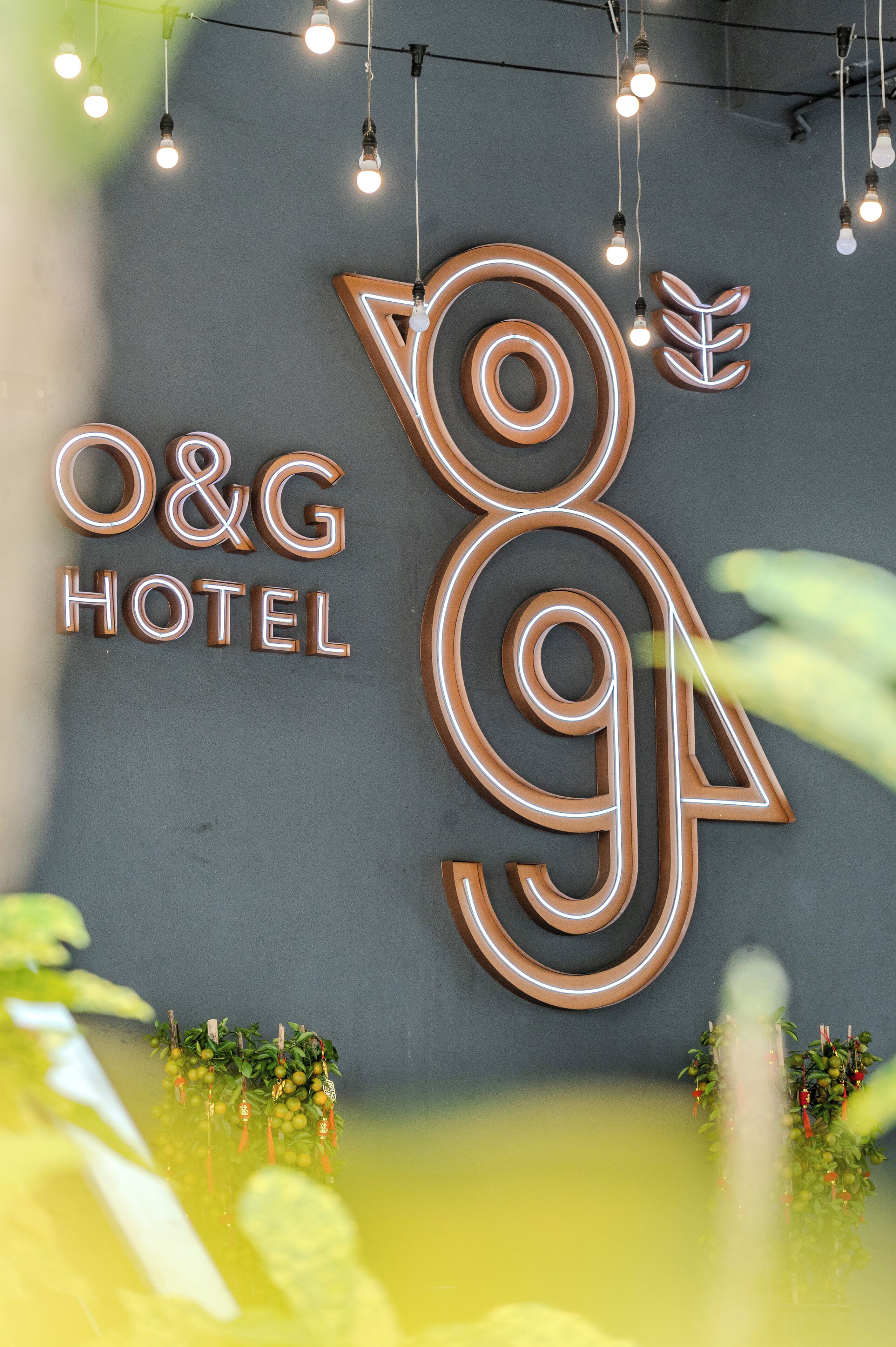A hotel sign with illuminated letters and a decorative leaf design.