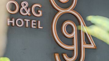 A hotel sign with illuminated letters and a decorative leaf design.