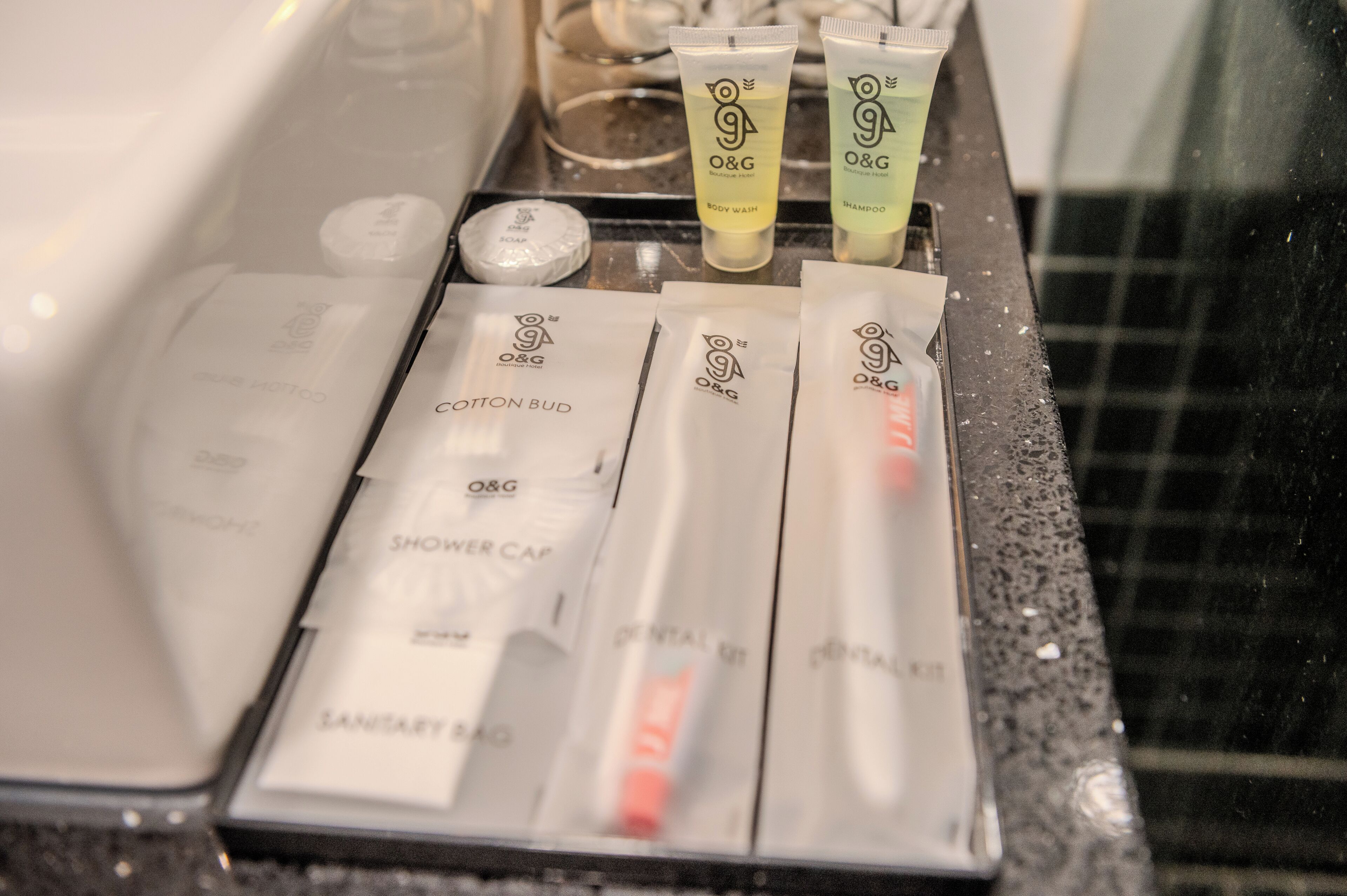 Articles de toilette et produits de bain sur le comptoir d’une salle de bain d’hôtel.