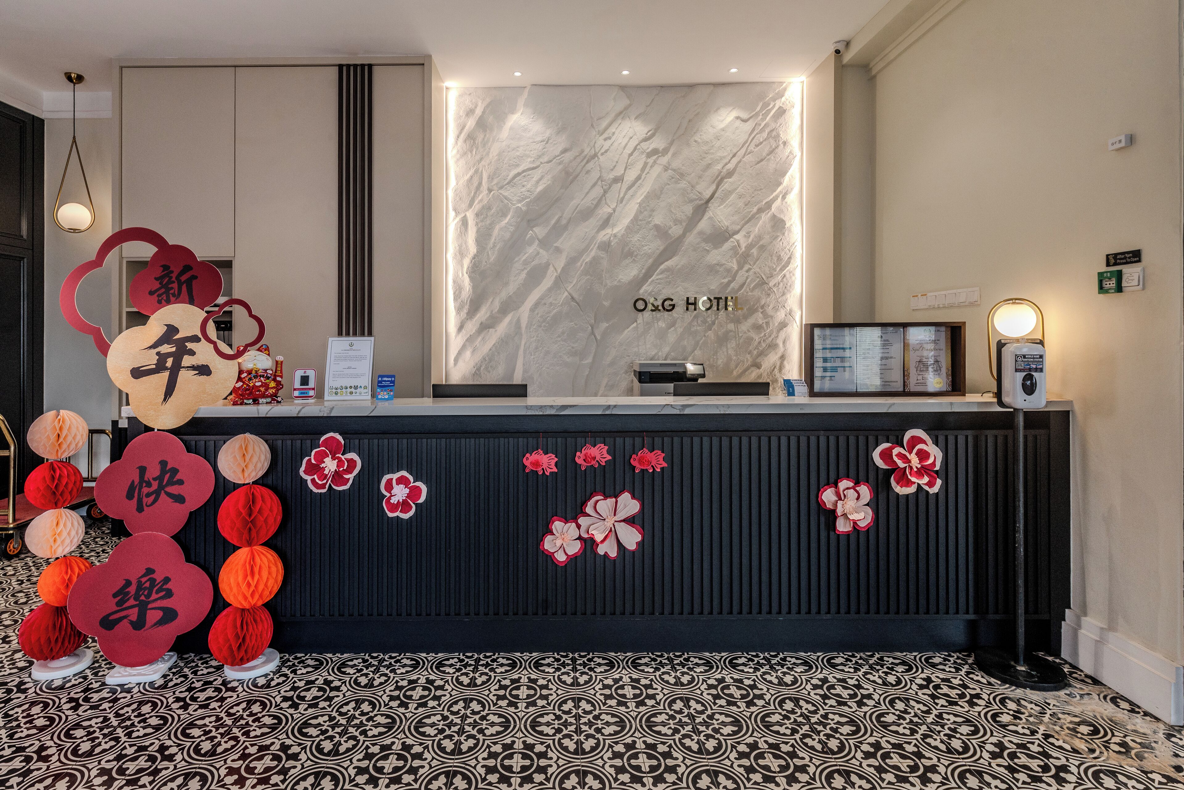 Een hotel receptiebalie met een marmeren wand en een zwart aanrecht.