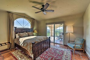 A bedroom with a large bed, a ceiling fan, a view through a window, and a chair. - Working Vineyard & Private Pool: Villa in Plymouth (Plymouth)
