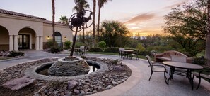 Relax in a serene outdoor space surrounded by a tranquil garden and a soothing fountain.
