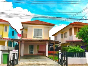 A residential building with a covered entrance, a satellite dish, and a gated driveway. - Little Tokyo House (Si Racha)