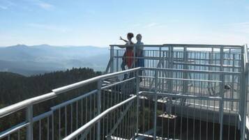 A metal observation platform with railings overlooking a mountainous landscape.