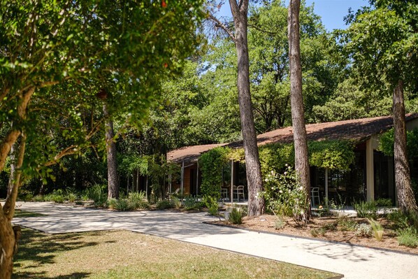 A building with a covered patio area surrounded by trees.