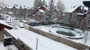 A snow-covered residential area with houses, a swimming pool, and a construction crane in the background. -  4 LIRONES - THE 4 SLEEPYHEAD DORMOUSES  (Benasque)