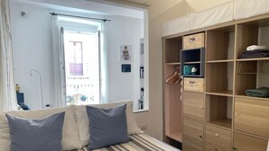 A bedroom with a bed, a wardrobe, and a window. - Pisani 32 at the Marina (Cagliari)