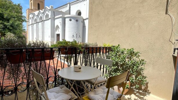 A balcony with a round table and two chairs, surrounded by a wrought iron fence. - Pisani 32 at the Marina (Cagliari)