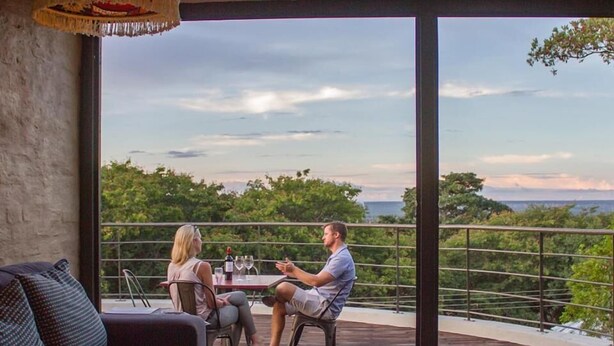 Un espacio de descanso moderno al aire libre con una mesa y sillas, con vistas a un paisaje pintoresco.