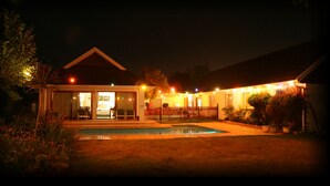 A house with a swimming pool, a covered patio, and string lights. - Wilmot Cottages (Gqeberha (Port Elizabeth))