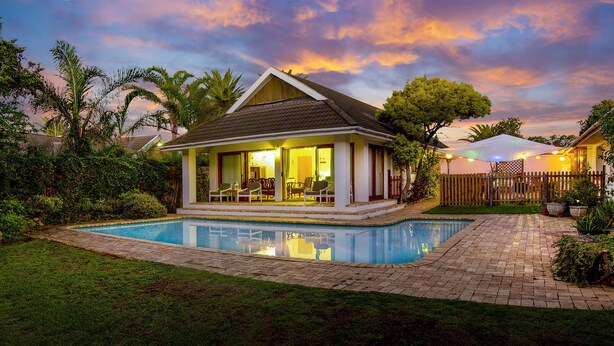 A house with a swimming pool, surrounded by greenery and a wooden fence. - Wilmot Cottages (Gqeberha (Port Elizabeth))