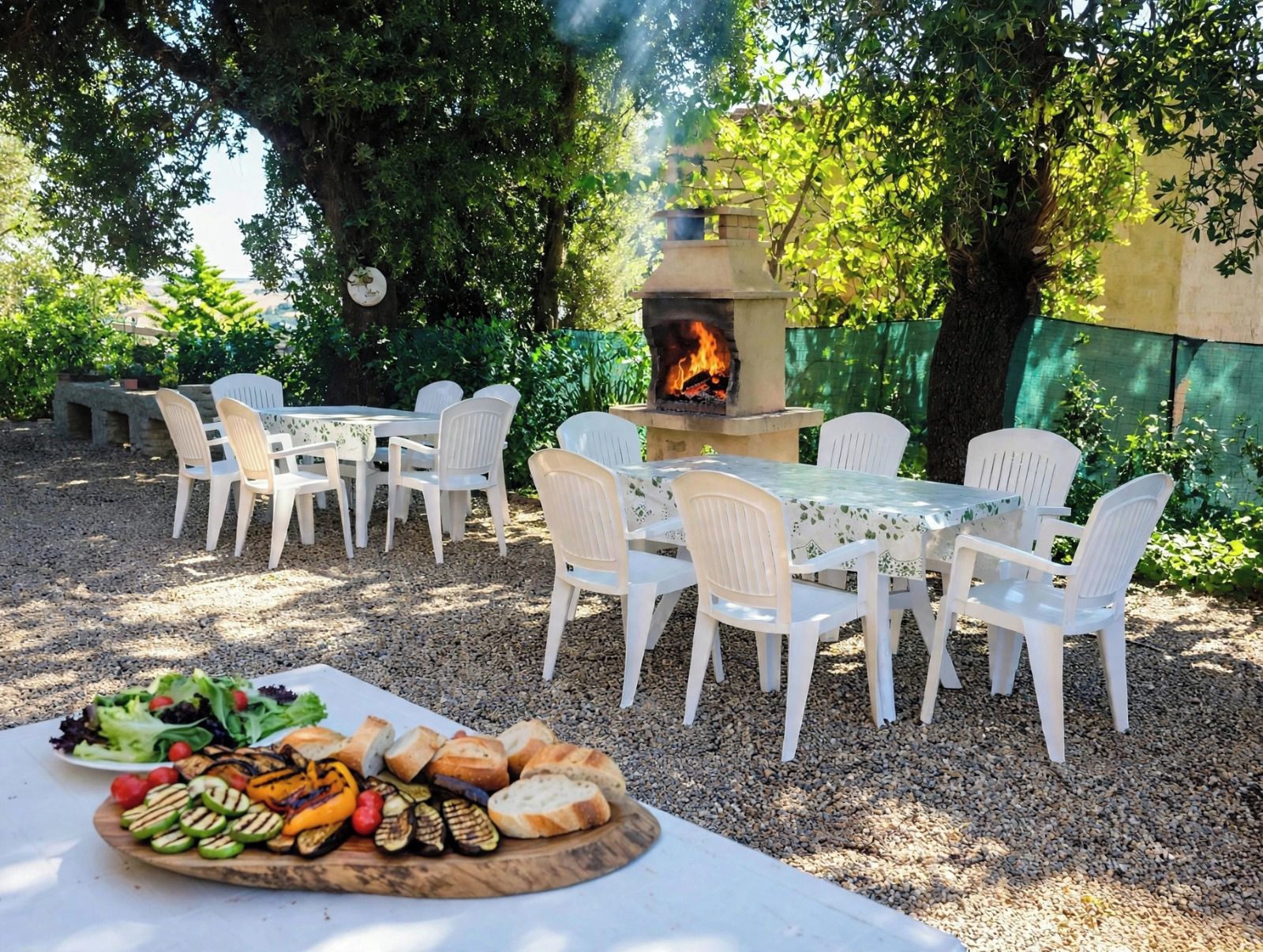 An outdoor dining area with a fire pit and a table set with food.