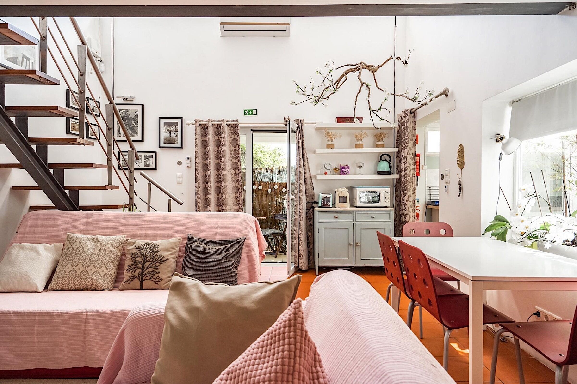 A modern interior with a staircase, a dining area, and a cozy seating area.