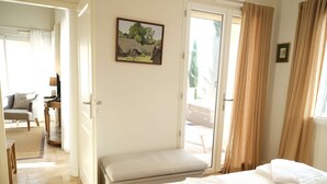 Une chambre d’hôtel avec un lit, une banquette, un bureau et une chaise.