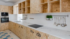 Una cocina moderna con armarios de madera, encimera de mármol y electrodomésticos integrados.