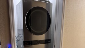 Una unidad de lavadora y secadora empotrada en la pared, con panel de control y toma de corriente.