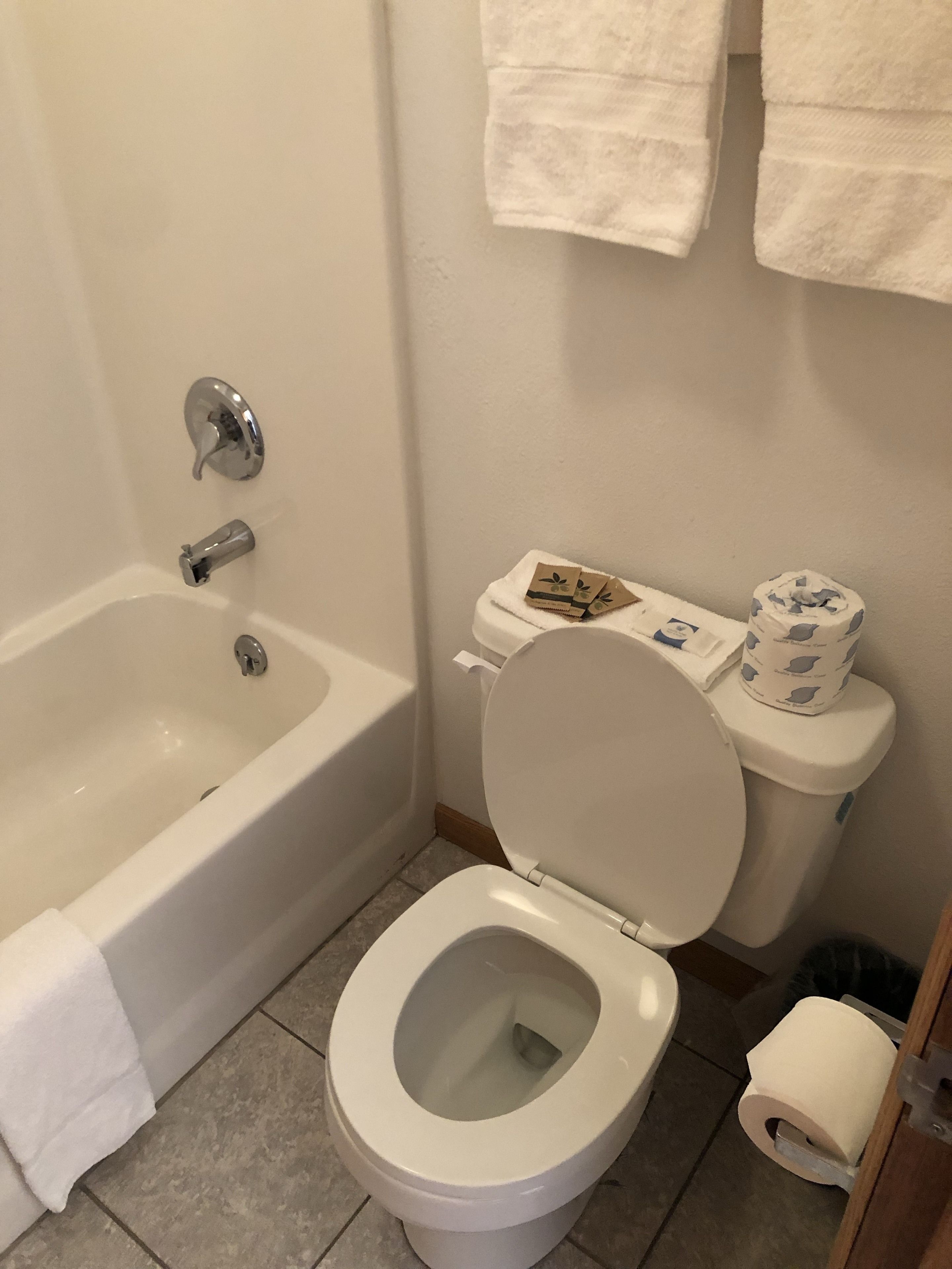 A bathroom with a bathtub, toilet, and a towel rack.