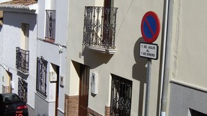 Eine enge Straße mit weißen Gebäuden, einem Verbotsschild und einem Datenschild.