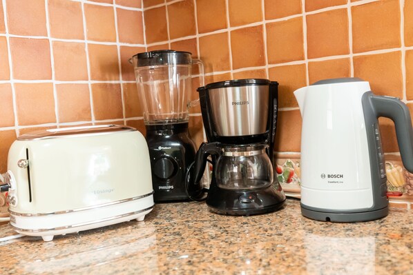 A kitchen counter with a white vintage toaster, a black Philips coffee maker, and a white Bosch kettle. - LV Premier Troia - TR1 (Grandola)