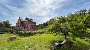 A large, historic building with a prominent tower and multiple windows, surrounded by lush greenery and a clear sky. - CHARACTER GITE with TERRACE and GARDEN, SPACIOUS and QUIET  (Gueberschwihr)