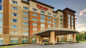 Edificio del Drury Inn & Suites con diseño moderno, con varios pisos, ventanas amplias y un área de entrada techada.