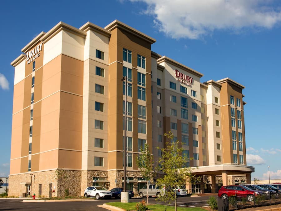 Un hotel Drury Inn & Suites con un diseño moderno, varios pisos y un estacionamiento.