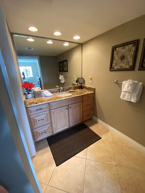 A bathroom with a sink, mirror, and towel rack. - SIESTA DUNES 1-406 LUXURY CONDO WITH A GREAT VIEW! (Sarasota)