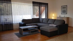 Una sala de estar moderna con un sofá modular, una mesa de centro y un mueble para la televisión.