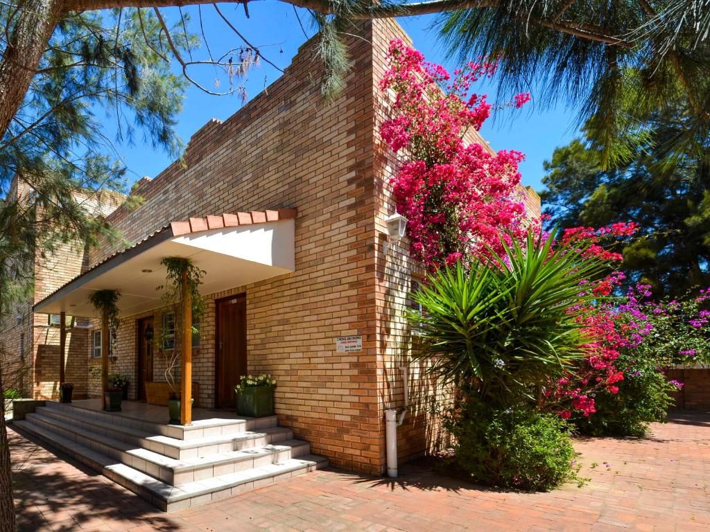 A brick building with a covered porch and steps leading to the entrance.