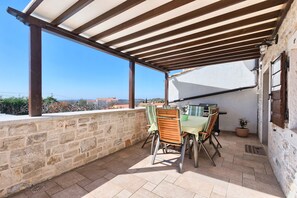 Relax in a serene outdoor space with a city view, featuring a table, chairs, and a potted plant.