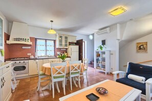 Cozy kitchen with dining area, bookshelf, and comfortable seating.